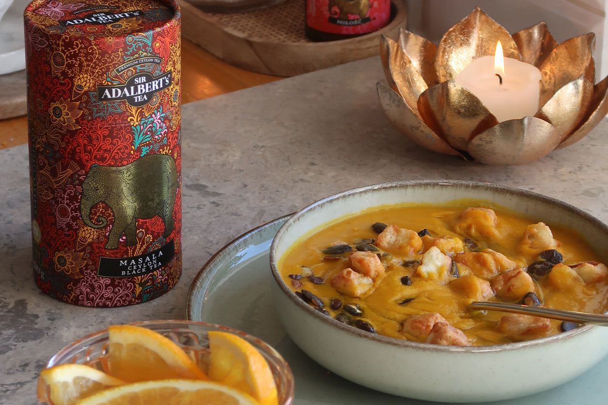 Elegancki tort matcha z kremem pistacjowym ozdobiony świeżymi kwiatami i miętą