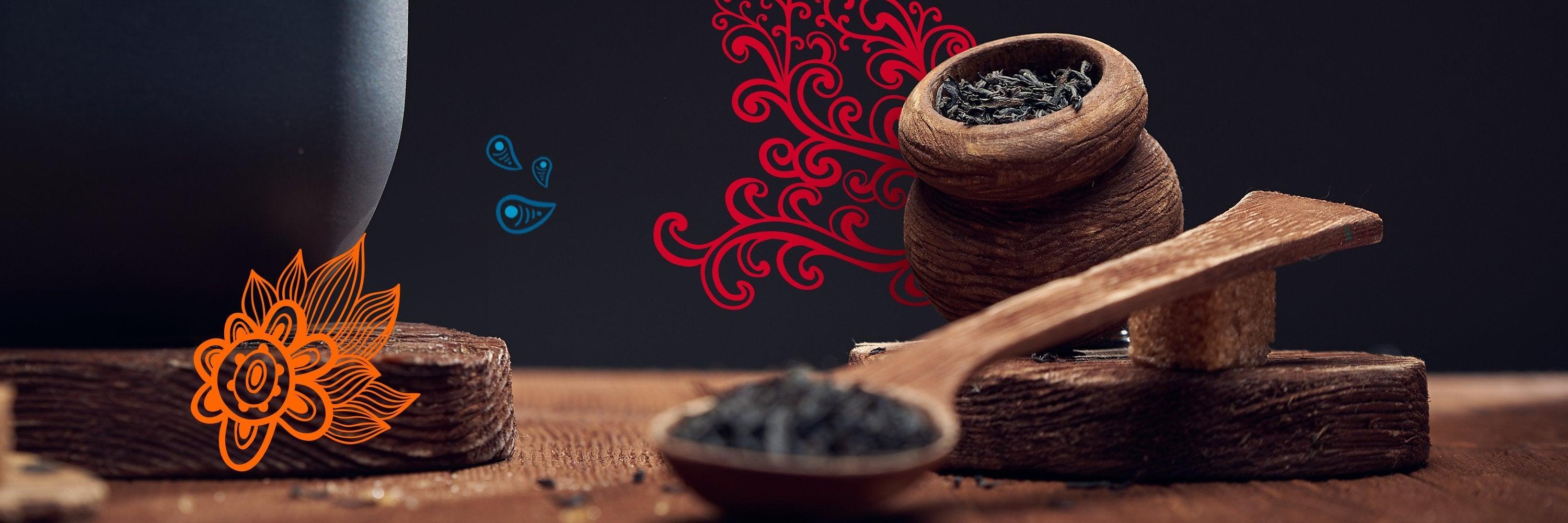 Suszone liście herbaty w drewnianej miseczce i łyżce na drewnianej powierzchni, dekoracje na czarnym tle