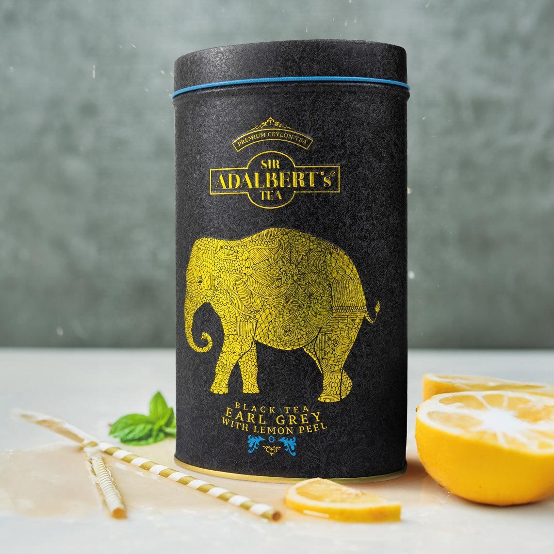Czarna puszka herbaty Sir Adalbert's Earl Grey z pomarańczą, żółty ornament słonia na czarnym tle
