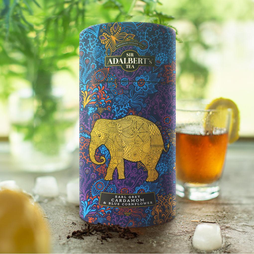 Puszka z herbatą Sir Adalbert's Tea Earl Grey Cardamom & Blue Cornflower na stole z lodem i cytryną