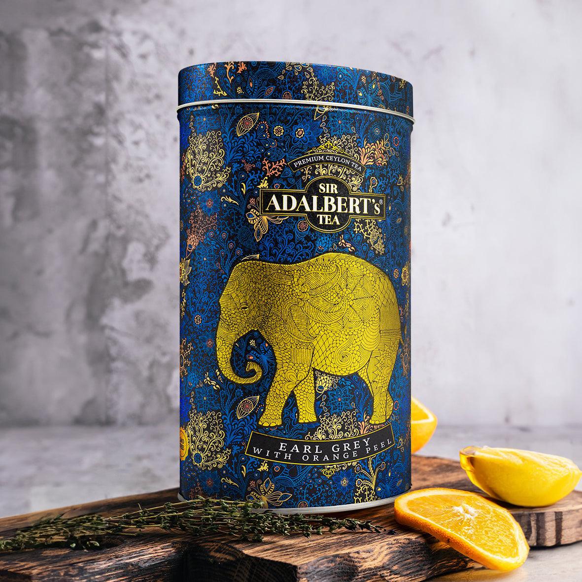 Puszka herbaty Sir Adalbert's Earl Grey z pomarańczą na drewnianej desce z plastrami owoców
