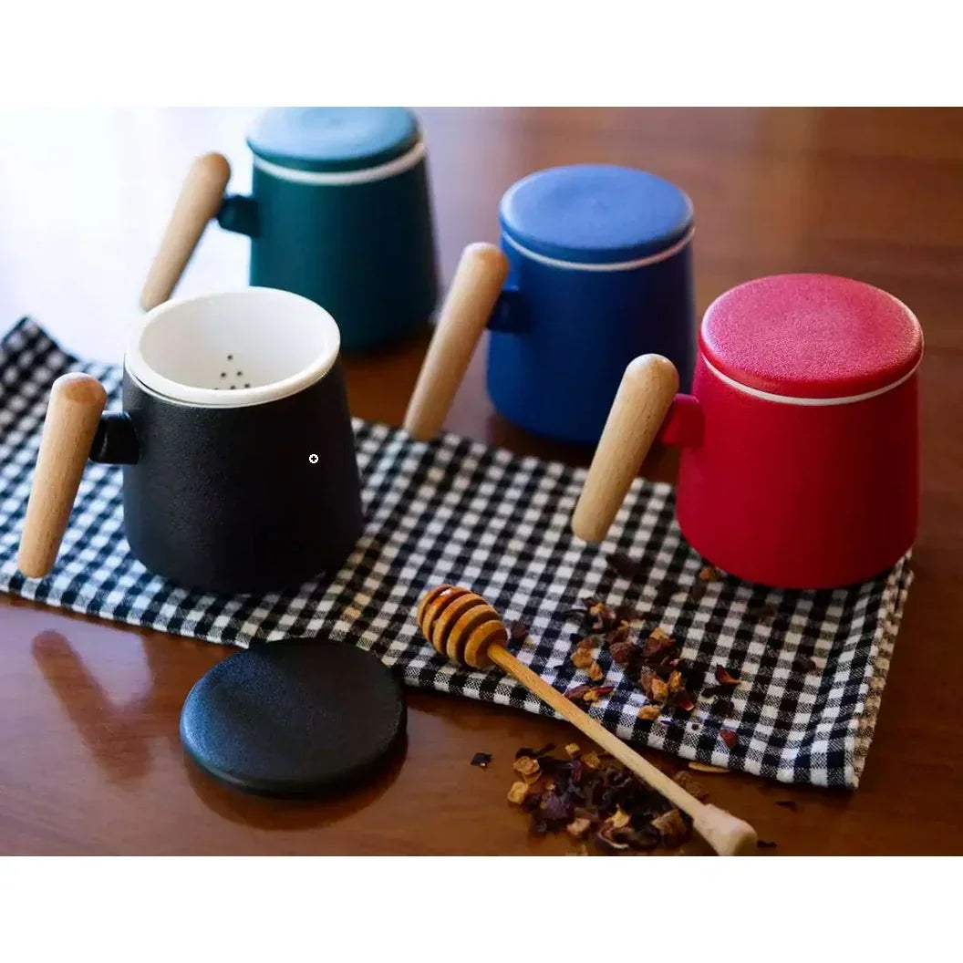 Ceramiczne kubki z drewnianymi uchwytami i sitkami, czarny, czerwony, niebieski, zielony na kratkowanej ściereczce