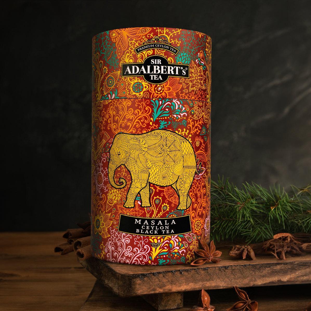 Puszka herbaty Sir Adalbert's Masala Ceylon black tea z żółtym słoniem i wzorami, przyprawy i gałązki na drewnianym stole