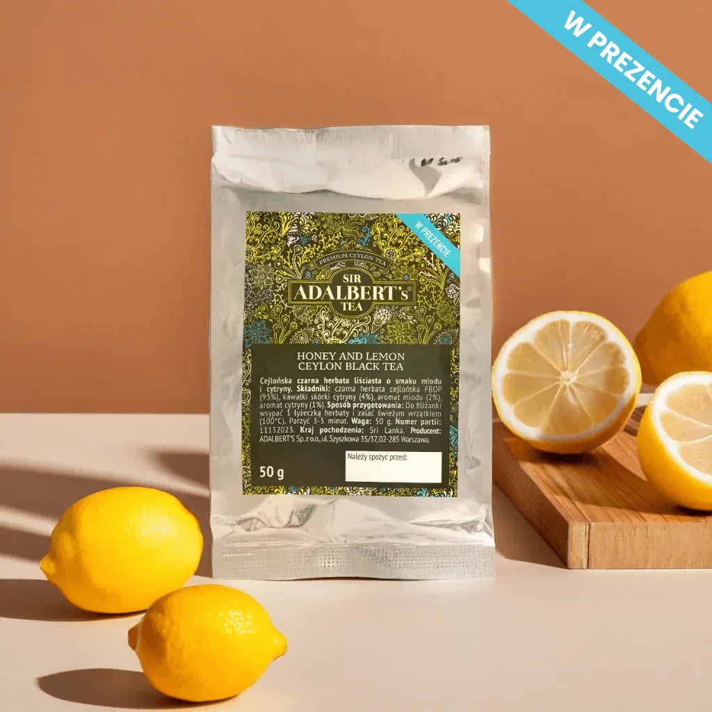 Opakowanie herbaty Sir Adalbert's Tea Honey and Lemon Ceylon black tea z cytrynami na stole