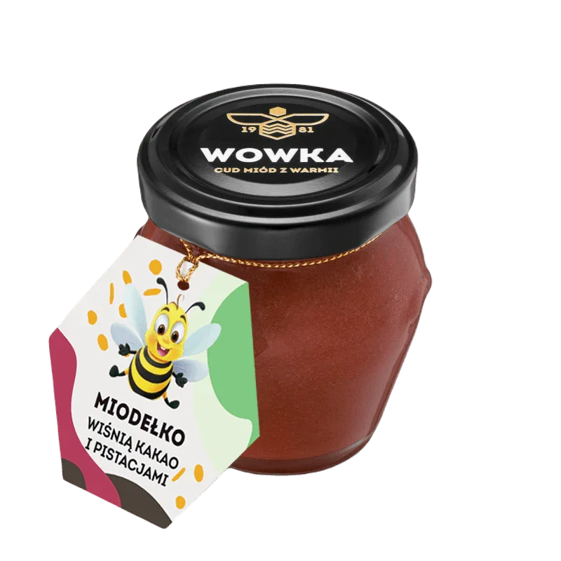 Słoik miodu Wowka wiśnia kakao pistacje z czarną zakrętką i kolorową etykietą z kreskówkową pszczółką